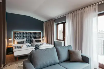 a living room with a couch and a bed at Avena Boutique Hotel by Artery Hotels in Kraków