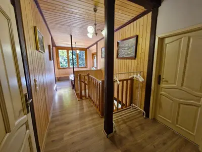 a hallway of a home with wooden walls and wooden floors at Rodzinny Dom Wypoczynkowy Grzechynia Carchla in Grzechynia