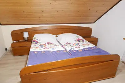 a wooden bed with two pillows on top of it at Rodzinny Dom Wypoczynkowy Grzechynia Carchla in Grzechynia