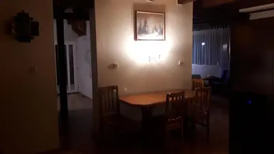 a dining room table with chairs and a light on the wall at Rodzinny Dom Wypoczynkowy Grzechynia Carchla in Grzechynia