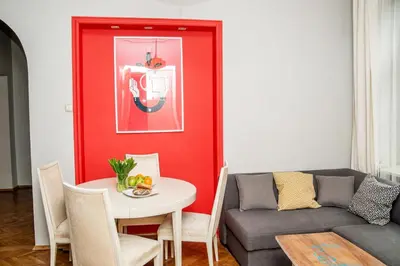 two beds in a small room with a window at Red Kurka Apartments in Kraków