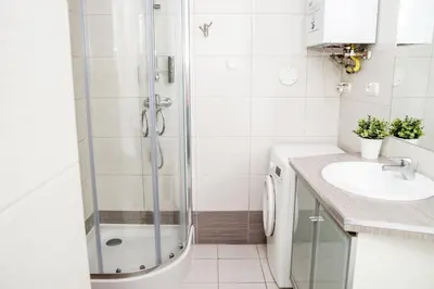 a white bathroom with a tub and a sink at Red Kurka Apartments in Kraków