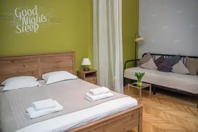 two beds in a room with green walls at Red Kurka Apartments in Kraków