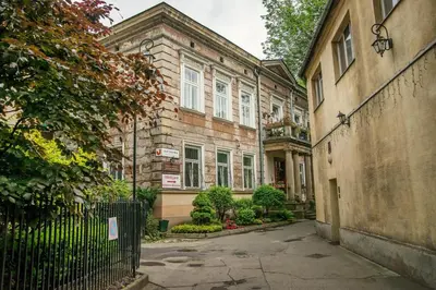 an empty street with a gate in front of a building at Red Kurka Apartments in Kraków