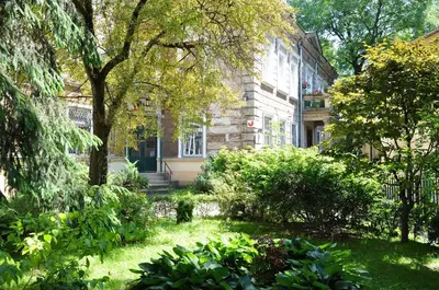 a building with windows and flowers in front of it at Red Kurka Apartments in Kraków