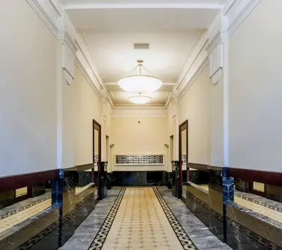 an empty hallway in a building with a light fixture at Miodowa Boutique Residence in Kraków