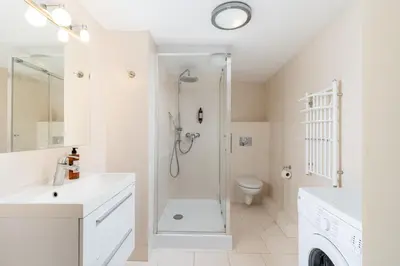 a white bathroom with a shower and a toilet at Miodowa Boutique Residence in Kraków