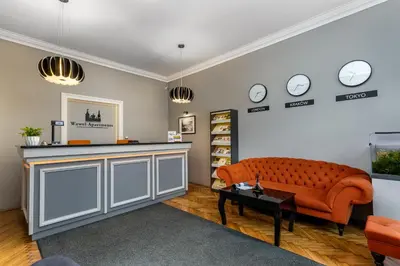 a living room with a couch and clocks on the wall at Miodowa Boutique Residence in Kraków