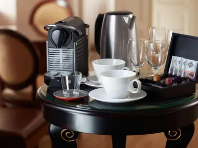 a table with a coffee maker and glasses on it at Miodowa Boutique Residence in Kraków