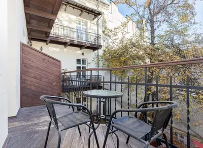 a patio with two chairs and a table on a balcony at Miodowa Boutique Residence in Kraków