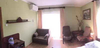 a living room with two chairs and a window at Pensjonat Przy Błoniach in Kraków