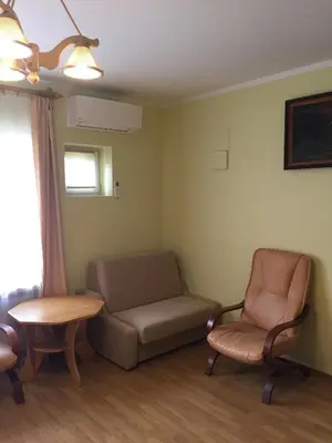 a living room with a couch and a table and a chair at Pensjonat Przy Błoniach in Kraków