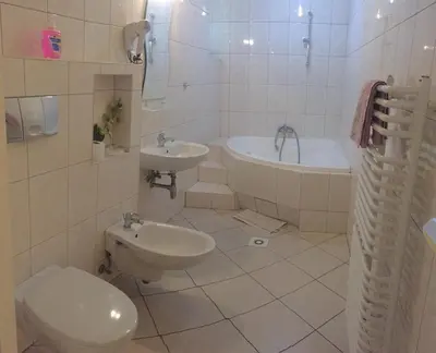 a bathroom with a toilet and a sink and a tub at Pensjonat Przy Błoniach in Kraków