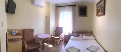 a bedroom with two beds and a table and a window at Pensjonat Przy Błoniach in Kraków