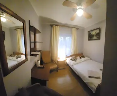 a room with two beds and a mirror and a window at Pensjonat Przy Błoniach in Kraków