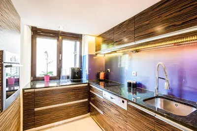 a kitchen with wooden cabinets and a sink and a window at Apartment Sare 11 in Kraków