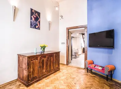 a living room with a tv on a blue wall at Apartment Sare 11 in Kraków
