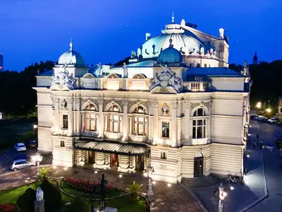 a large white building at night with lights at Apartment Sare 11 in Kraków
