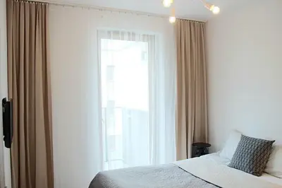 a bedroom with a bed and a large window at SHOQ STUDIO nice apartment with private parking in Kraków