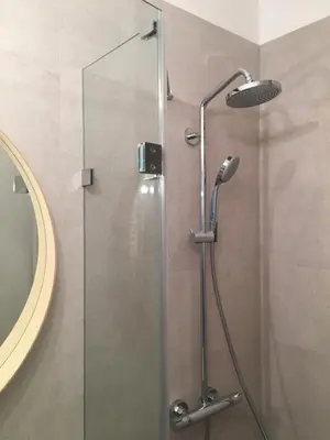 a shower with a glass door in a bathroom at SHOQ STUDIO nice apartment with private parking in Kraków