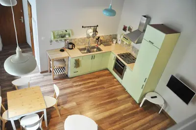 a kitchen with green cabinets and a wooden floor at Bożego Ciała by Homeprime in Kraków