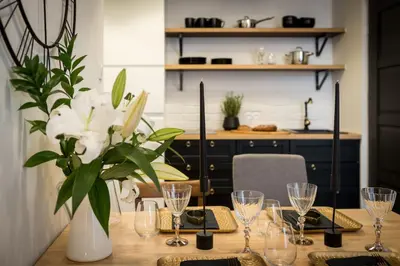 a dining room table with a vase of flowers and glasses at Bożego Ciała by Homeprime in Kraków