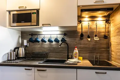 a kitchen with a sink and a counter with utensils at ENERGYLANDIA Zator Apartament Asia in Zator