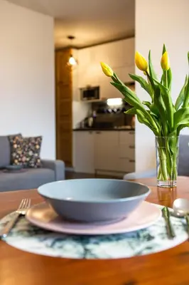 a bowl on a table with a vase with yellow flowers at ENERGYLANDIA Zator Apartament Asia in Zator