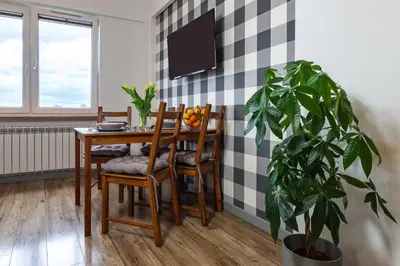 a dining room with a table and a plant at ENERGYLANDIA Zator Apartament Asia in Zator
