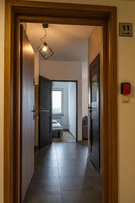 a hallway with two doors and a room with a bed at ENERGYLANDIA Zator Apartament Asia in Zator