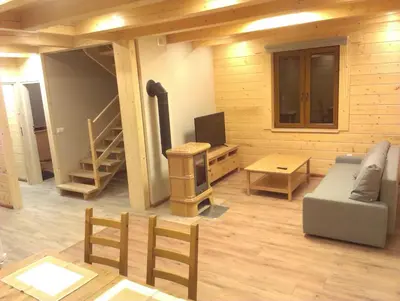 two beds in a room with a window and a table at Słoneczne Chaty pod Sonami Kasina Wielka in Kasina Wielka