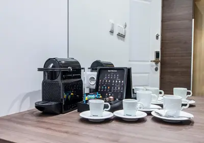 a table with coffee cups and a toaster at Aparthotel Rakowicka Residence in Kraków