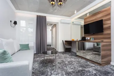 a living room with a white couch and a desk at Aparthotel Rakowicka Residence in Kraków