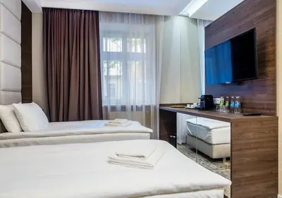 a hotel room with two beds and a television at Aparthotel Rakowicka Residence in Kraków
