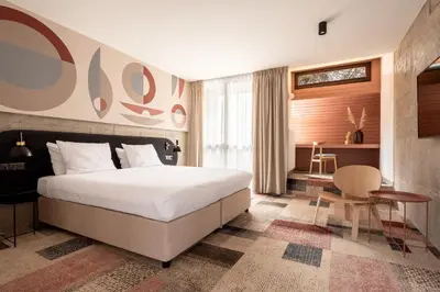 a bedroom with a bed and a table and a chair at Forest Hotel in Kraków