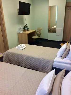 a hotel room with two beds and a desk at 3Rooms in Kraków