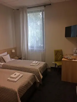a hotel room with two beds and a window at 3Rooms in Kraków