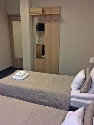 a hotel room with two beds and a mirror at 3Rooms in Kraków