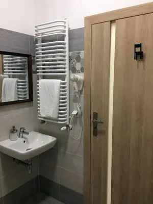 a bathroom with a sink and a mirror at 3Rooms in Kraków