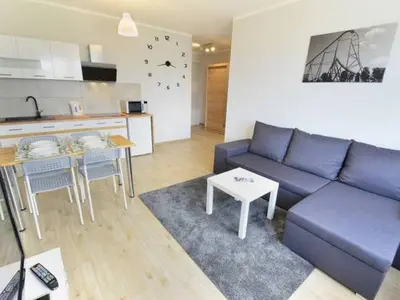 a living room with a blue couch and a kitchen at Apartament Korazone ZATOR in Zator