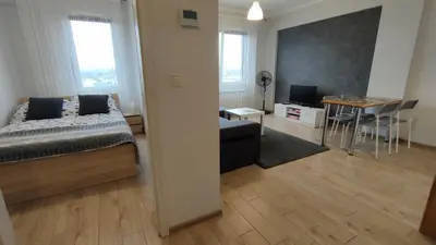 a bedroom with a bed and a dining room with a table at Apartament Korazone ZATOR in Zator