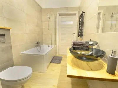 a bathroom with a bowl sink and a toilet at Apartament Korazone ZATOR in Zator