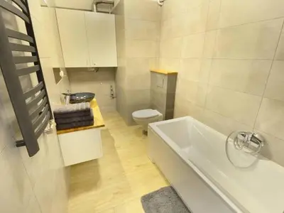 a bathroom with a white tub and a toilet at Apartament Korazone ZATOR in Zator