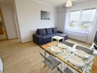 a living room with a blue couch and a table at Apartament Korazone ZATOR in Zator