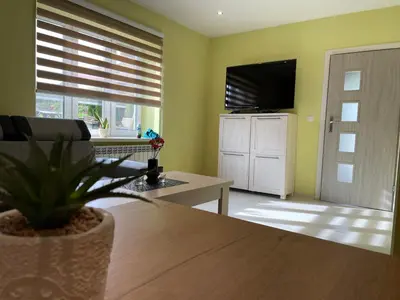 a living room with a table and a television at Country Rooms in Bachowice
