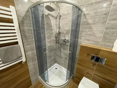 a shower with a glass door in a bathroom at Country Rooms in Bachowice