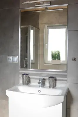 a bathroom with a white sink and a mirror at Domki Komfort całoroczne in Zator