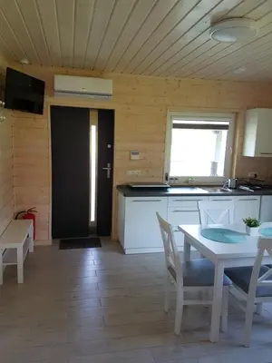 a kitchen with a table and a black door at Domki Komfort całoroczne in Zator
