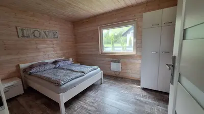 a bedroom with a bed in a room with a window at Domki Komfort całoroczne in Zator