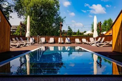a swimming pool with lounge chairs and umbrellas at Western Camp Resort in Zator